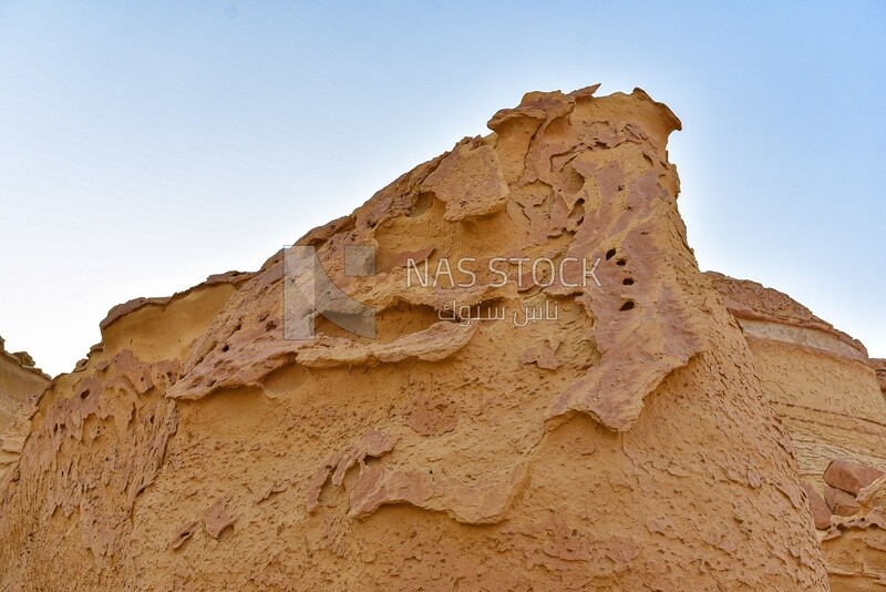 A scene of rock formations on a sandy mountain in the Wadi El Hitan desert in Egypt