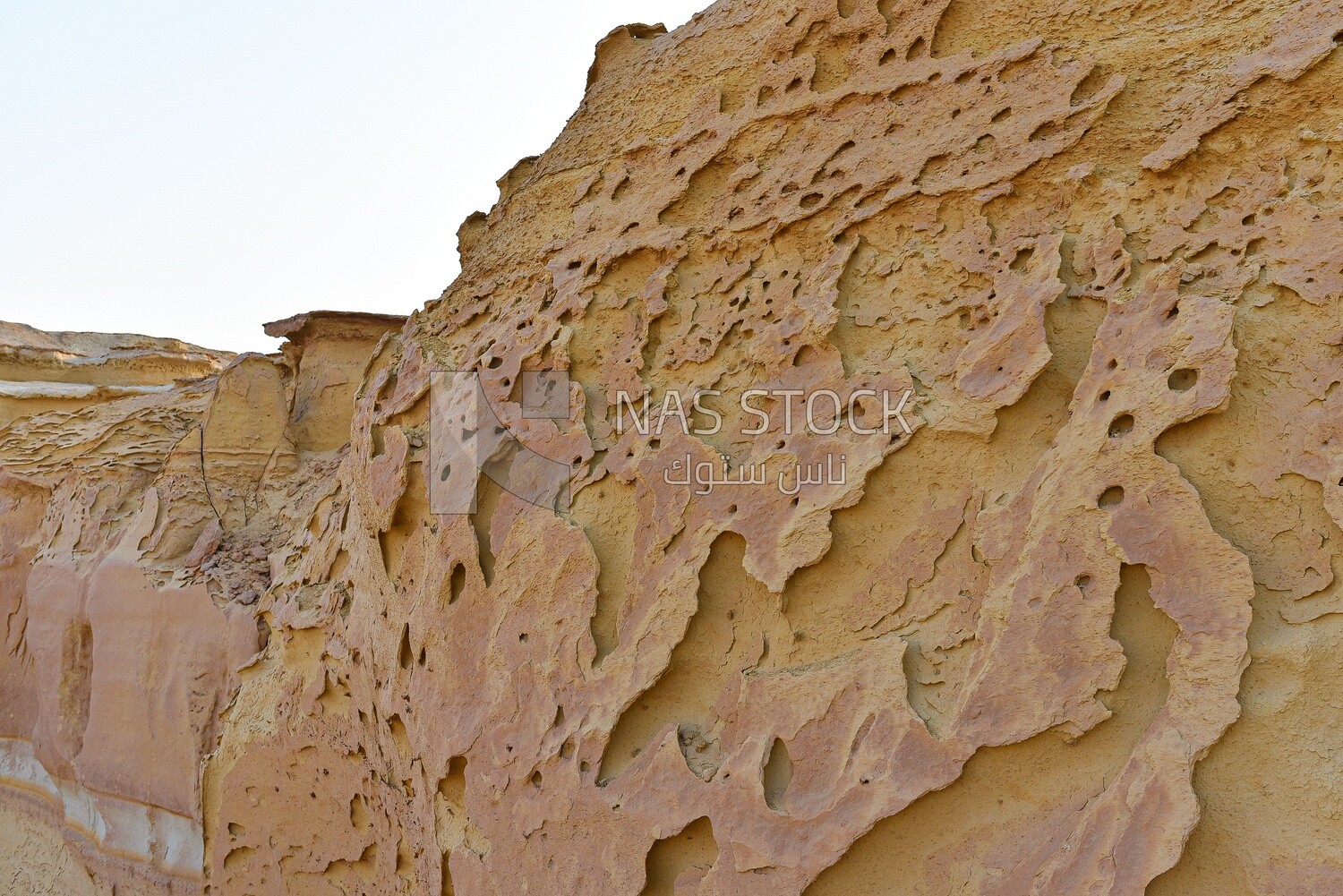 Scene of pits and passages carved on a sandy mountain in the Wadi El Hitan desert in Egypt