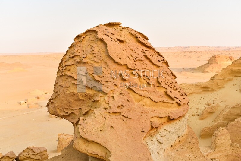 A scene of rock formations on a sandy mountain in the Wadi El Hitan desert in Egypt