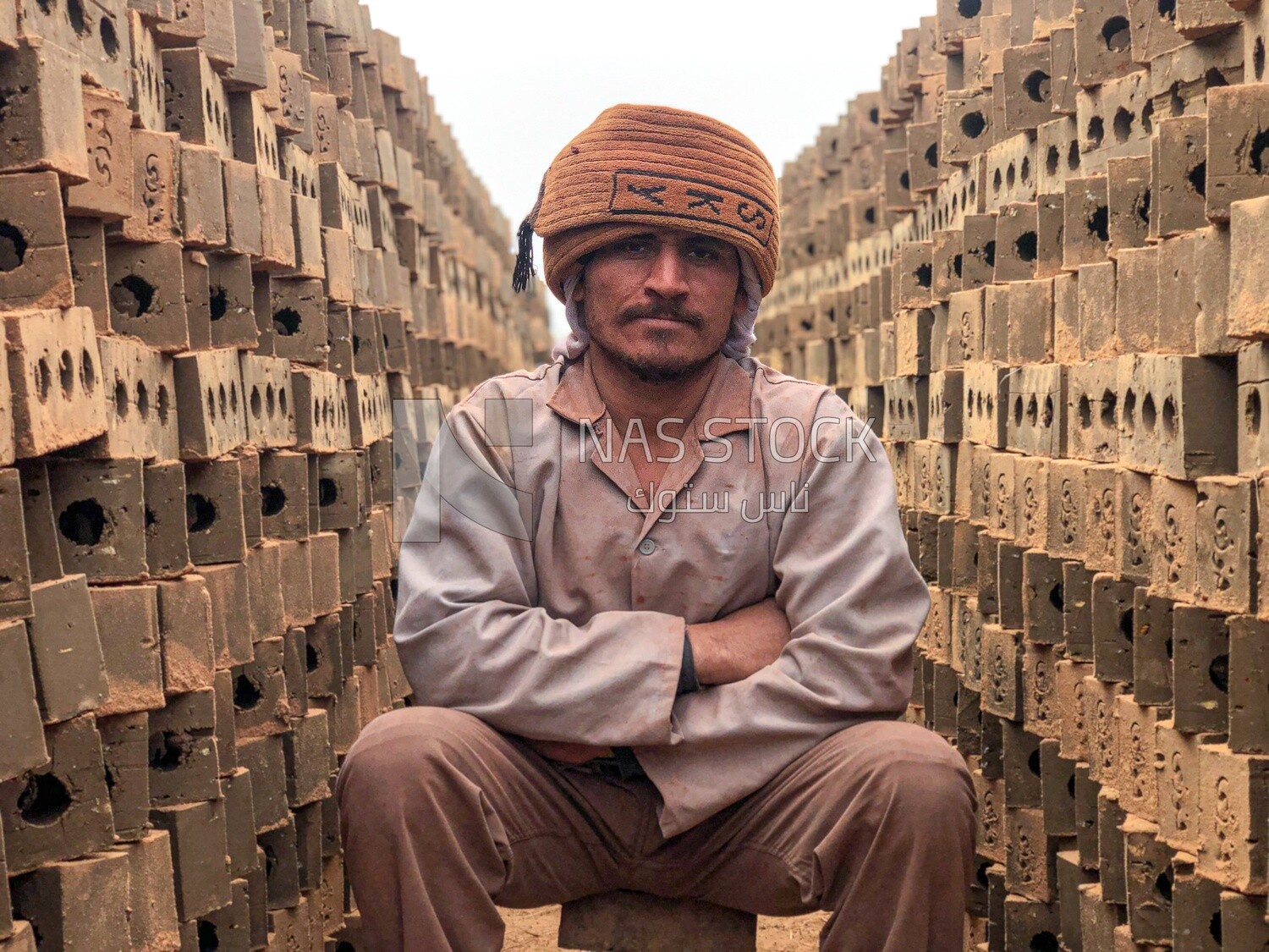 An Egyptian craftsman arranging the bricks