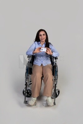 girl sitting in a wheelchair holding an ID, Services for people with disabilities