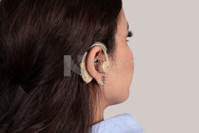 girl with hearing impairment wearing earphones for the deaf and mute