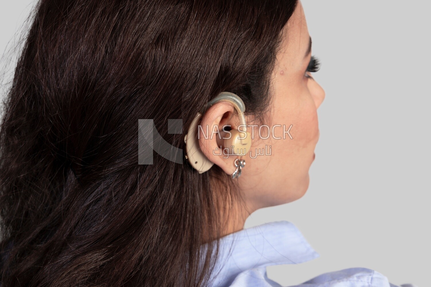 hearing aid for the hearing impaired in a woman&#39;s ear