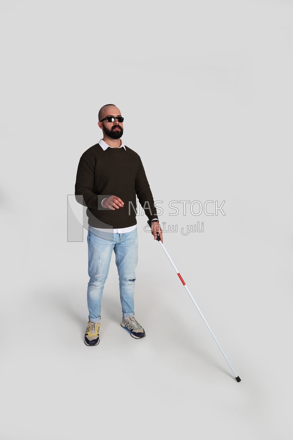 Visually impaired man wearing glasses with walking stick