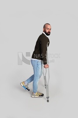 شاب يستند على عكاز وينظر الى الكاميرا