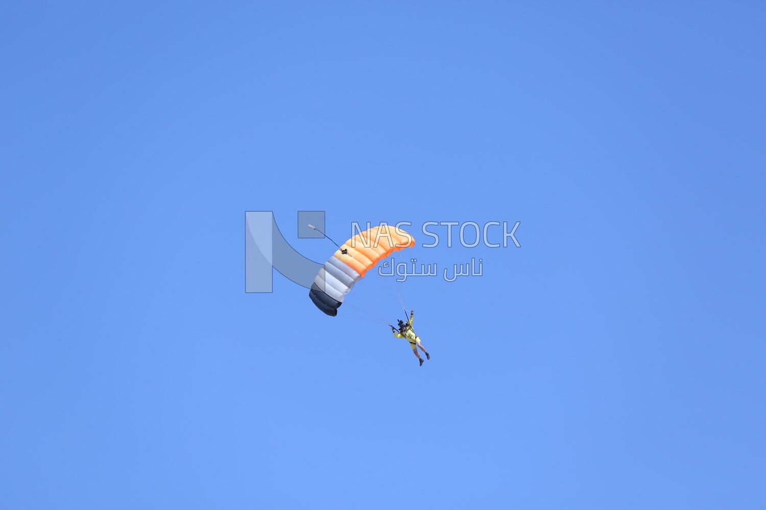 Scene of a person flying in the sky wearing a parachute