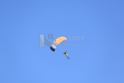 Scene of a person flying in the sky wearing a parachute