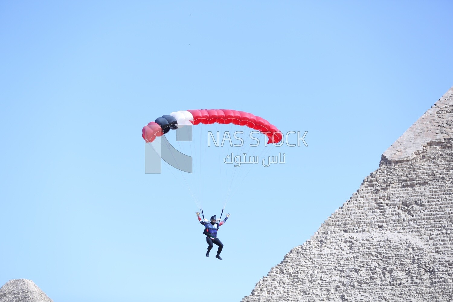 Scene of  people flying in the sky wearing a parachutes