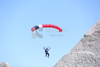 Scene of  people flying in the sky wearing a parachutes