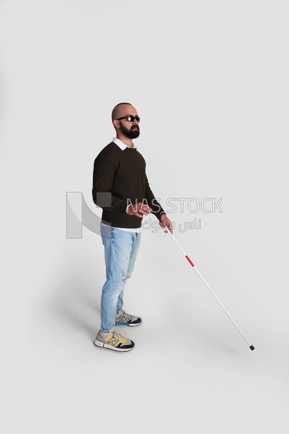 blind man holding a walking stick and wearing glasses