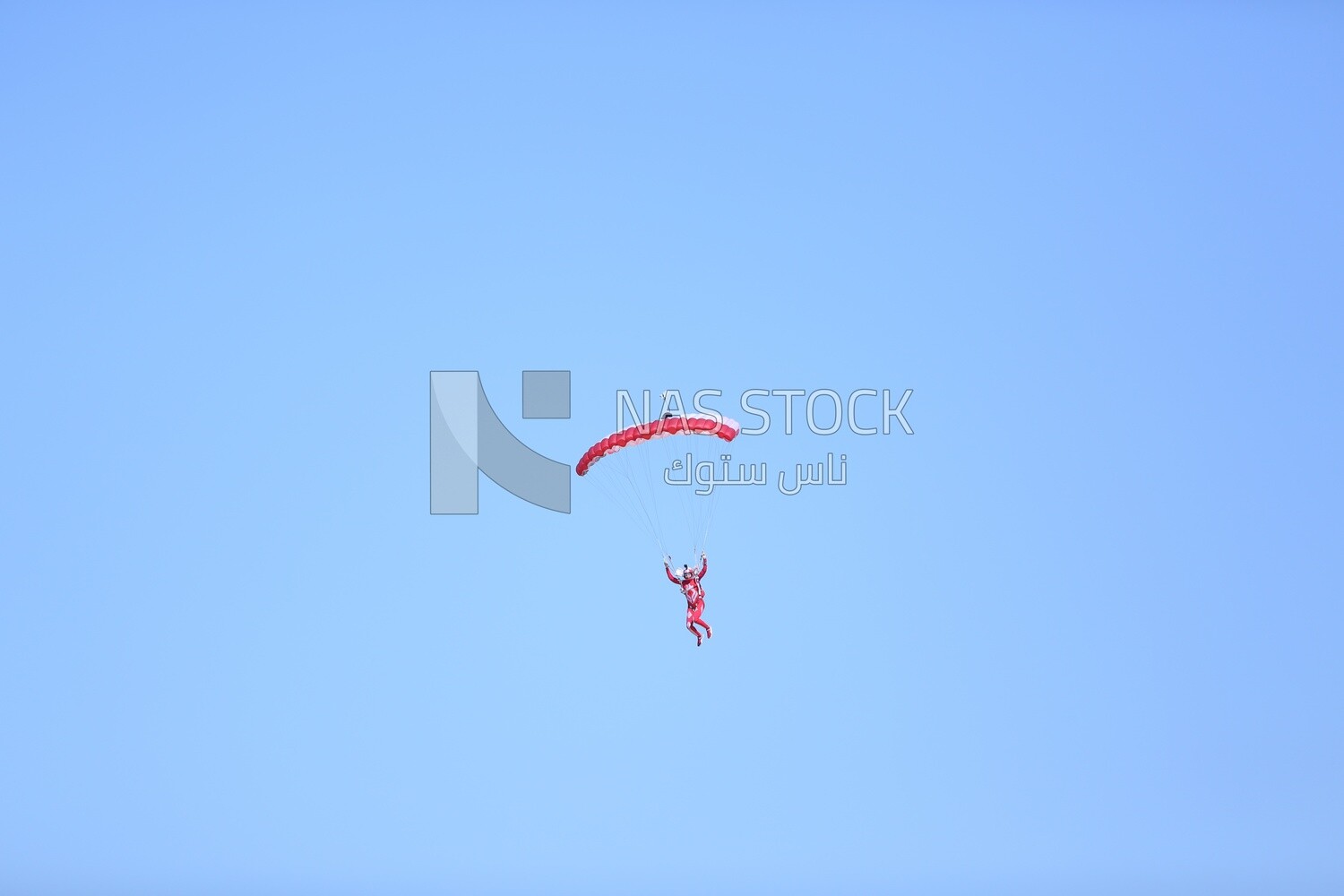 Scene of a person flying in the sky wearing a parachute
