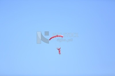 Scene of a person flying in the sky wearing a parachute