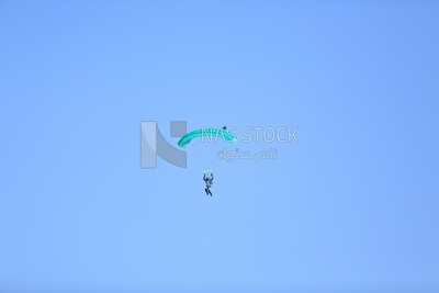 Scene of a person flying in the sky wearing a parachute