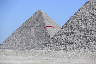 The scene of a person parachuting on the land of the pyramids in Egypt