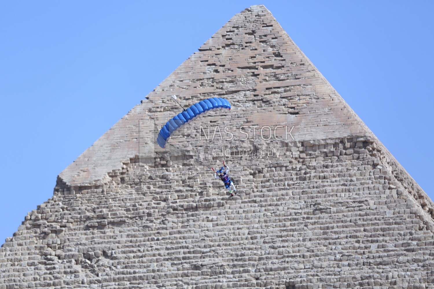 The scene of a person parachuting on the land of the pyramids in Egypt