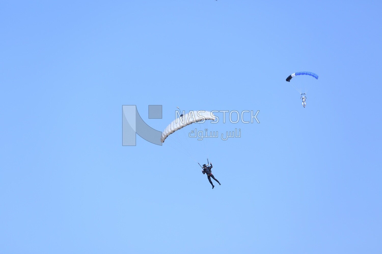 Scene of a person flying in the sky wearing a parachute