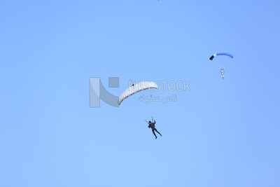 Scene of a person flying in the sky wearing a parachute