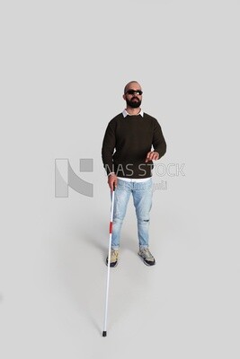 blind young man wearing glasses and holding a walking stick trying to figure out his way