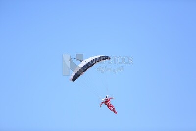Scene of a person flying in the sky wearing a parachute