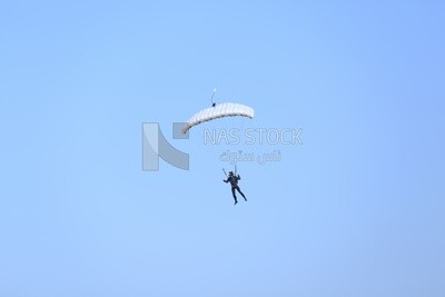 Scene of  people flying in the sky wearing a parachutes