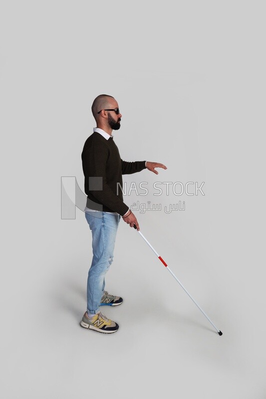 blind man using a walking stick and wearing glasses