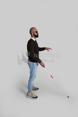 blind man using a walking stick and wearing glasses