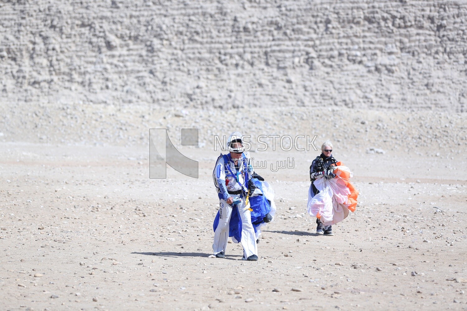 Tourists descending safely from a jump holding parachutes