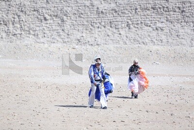 Tourists descending safely from a jump holding parachutes