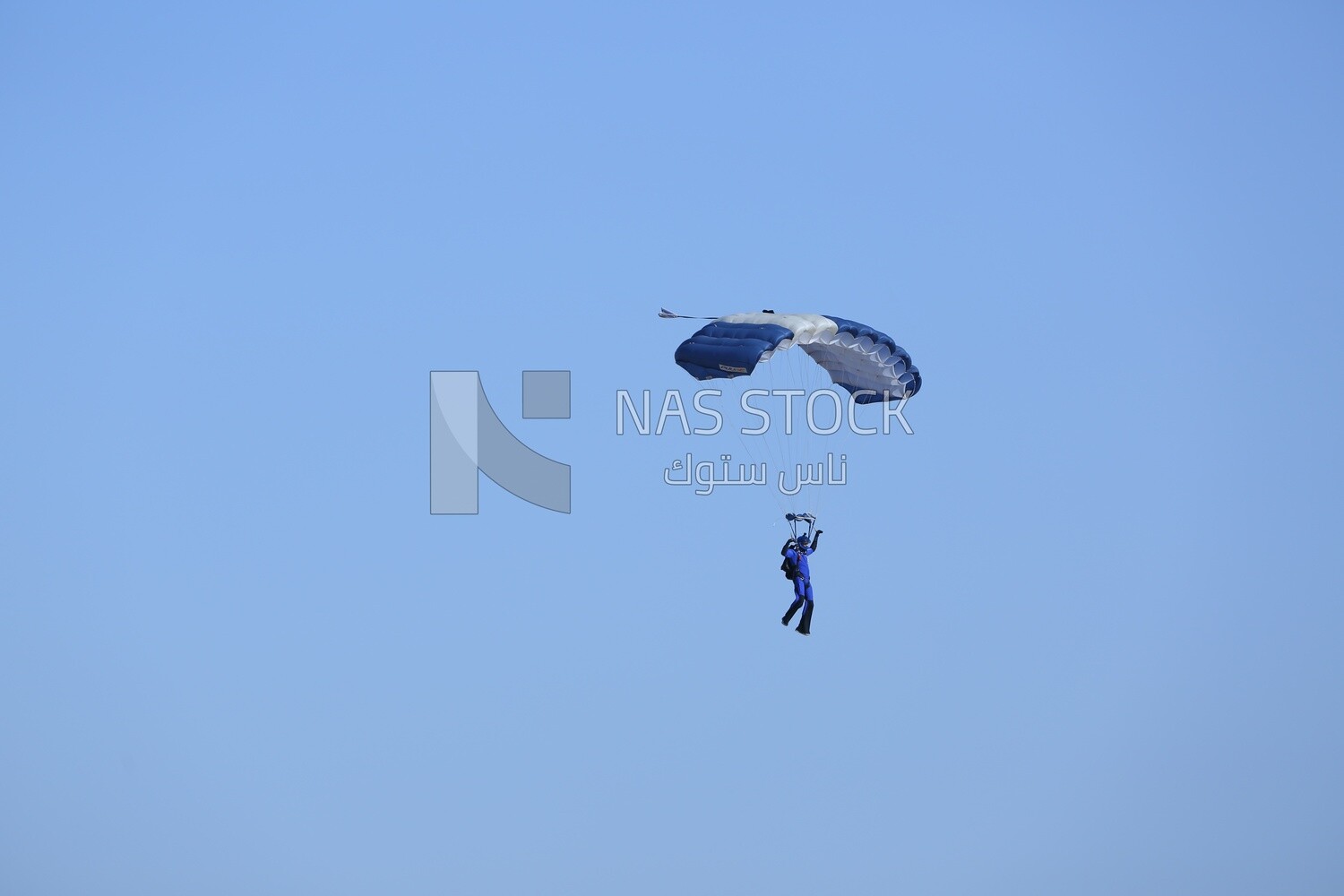 A person flying in the sky wearing a parachute
