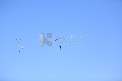 Scene of a person flying in the sky wearing a parachute