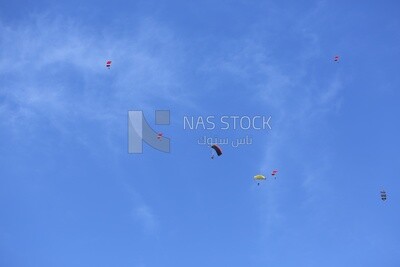 Scene of a person flying in the sky wearing a parachute