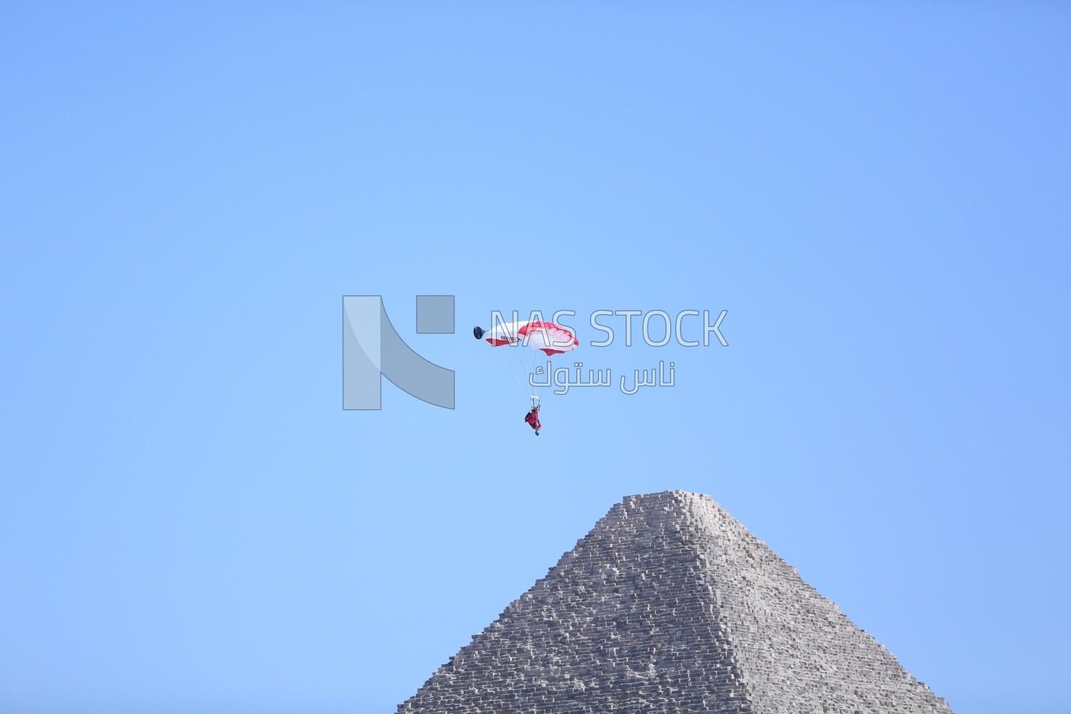 A scene of people skydiving over the pyramids