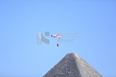 A scene of people skydiving over the pyramids