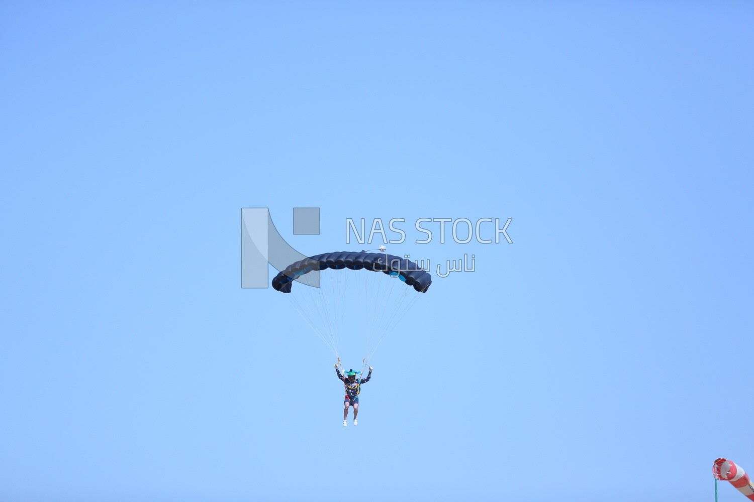 Scene of a person flying in the sky wearing a parachute