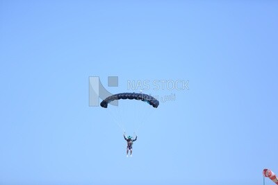 Scene of a person flying in the sky wearing a parachute