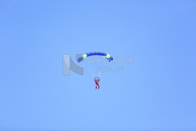Person flying in the sky wearing a parachute