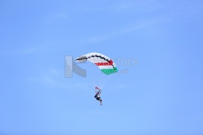 Person flying in the sky wearing a parachute