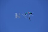 Person flying in the sky wearing a parachute