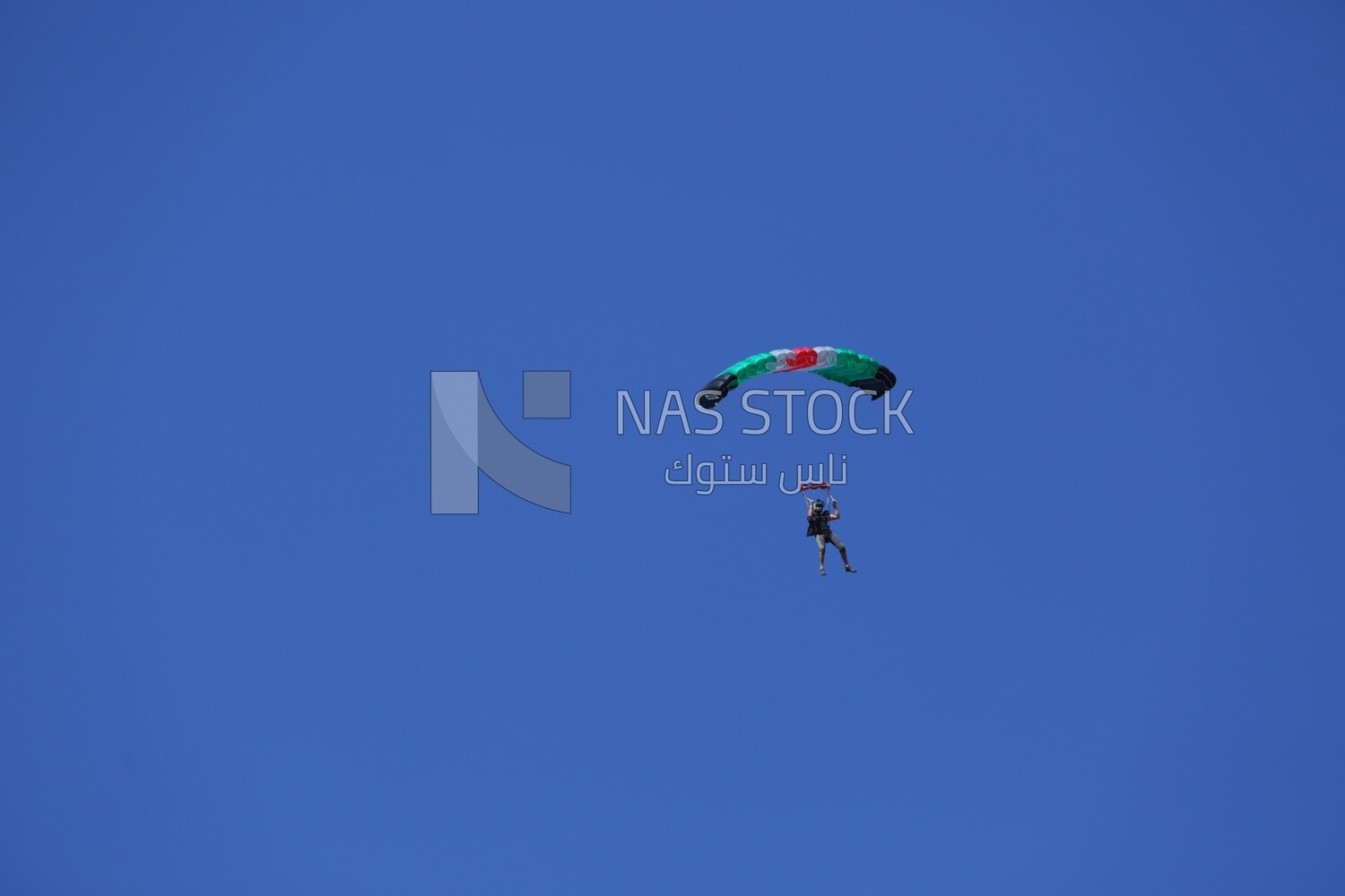 Person flying in the sky wearing a parachute
