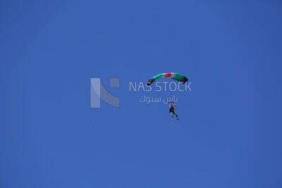 Person flying in the sky wearing a parachute