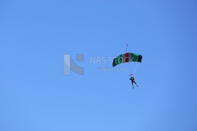 Person flying in the sky wearing a parachute