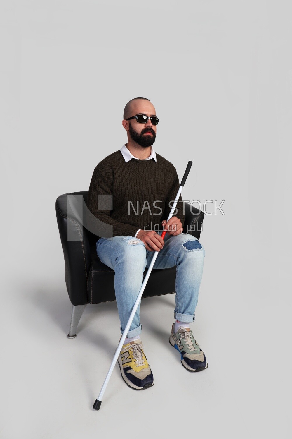 blind man sitting on a chair, wearing glasses