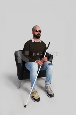 blind man sitting on a chair, wearing glasses