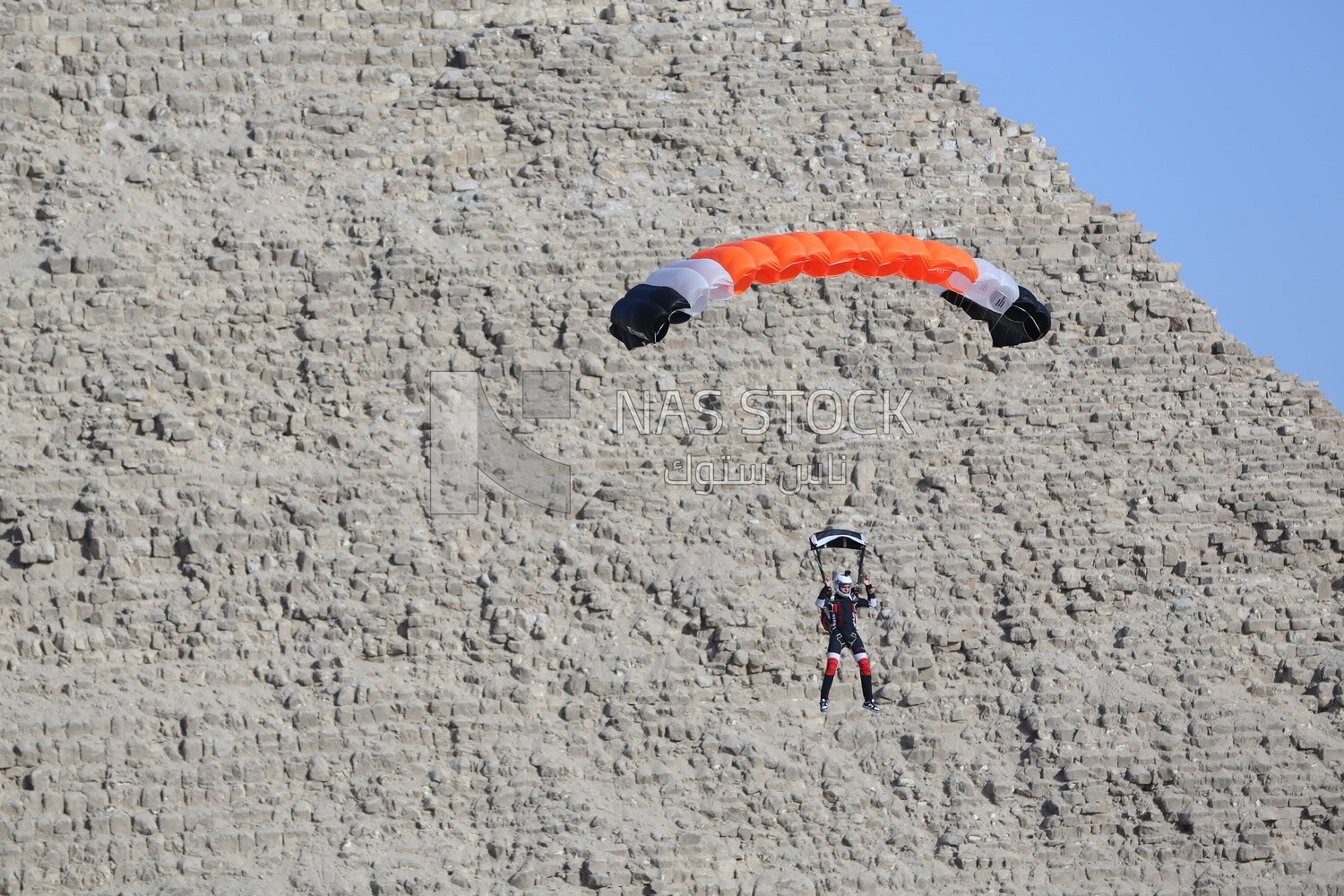 A person about to land with a parachute next to the Great Pyramid in Egypt