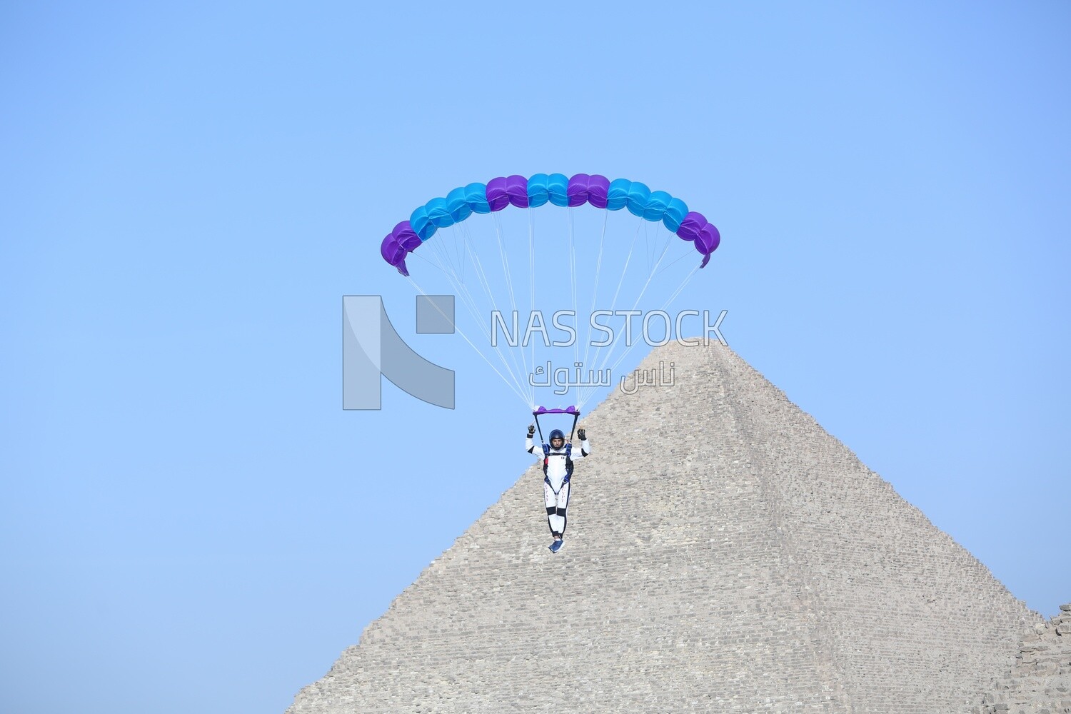 A person about to land with a parachute next to the pyramids in Egypt