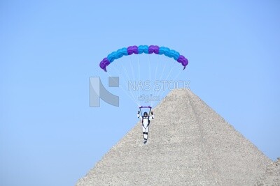 A person about to land with a parachute next to the pyramids in Egypt