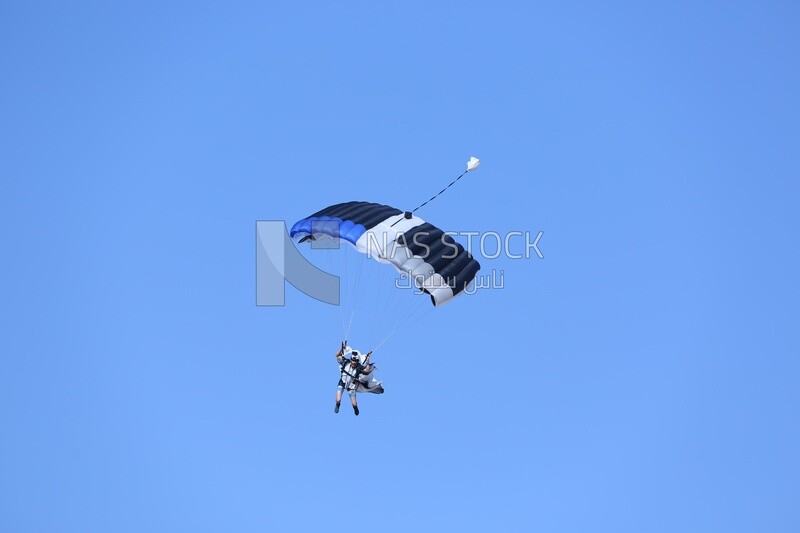 A person flying in the sky wearing a parachute