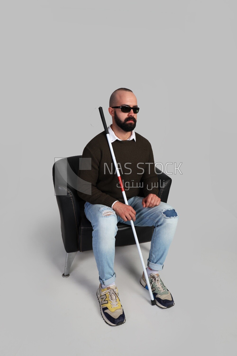blind man wearing glasses and sitting on a chair