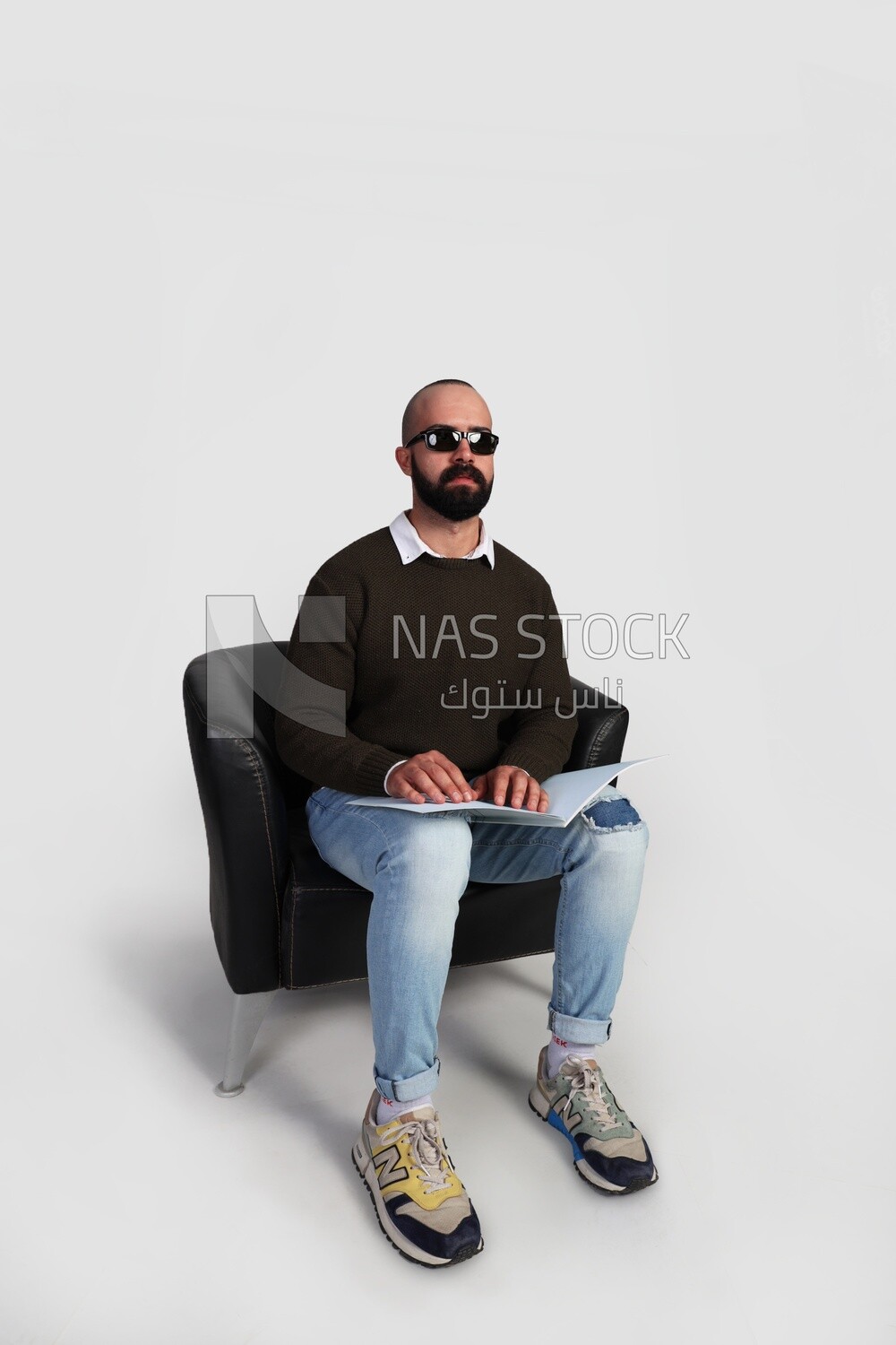 blind man wearing glasses and using Braille to read a book