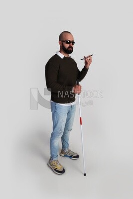 blind man wearing glasses listening to a voice recording on the phone